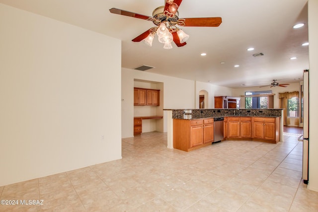 kitchen with dark stone countertops, ceiling fan, kitchen peninsula, and light tile patterned flooring