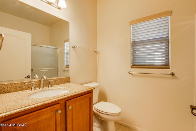 bathroom featuring tile patterned flooring, vanity, toilet, and a wealth of natural light