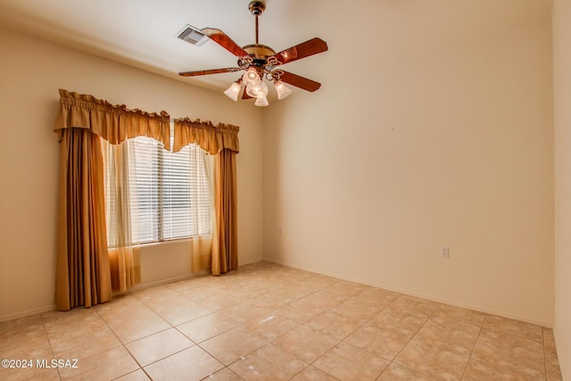 tiled empty room featuring ceiling fan