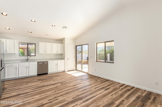 kitchen with visible vents, a sink, stainless steel dishwasher, white cabinets, and light countertops