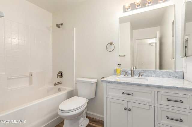 full bath featuring toilet, shower / tub combination, wood finished floors, baseboards, and vanity