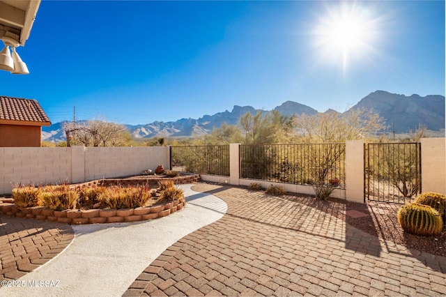 view of patio with a mountain view and fence