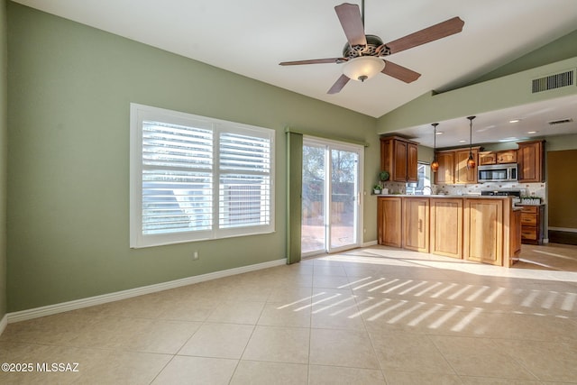 kitchen featuring ceiling fan, pendant lighting, vaulted ceiling, decorative backsplash, and light tile patterned floors