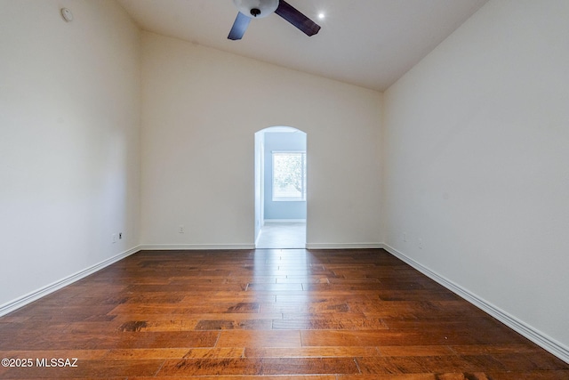 empty room featuring dark hardwood / wood-style floors, ceiling fan, and vaulted ceiling