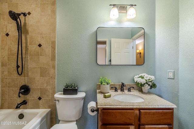 full bathroom featuring vanity, toilet, and tiled shower / bath