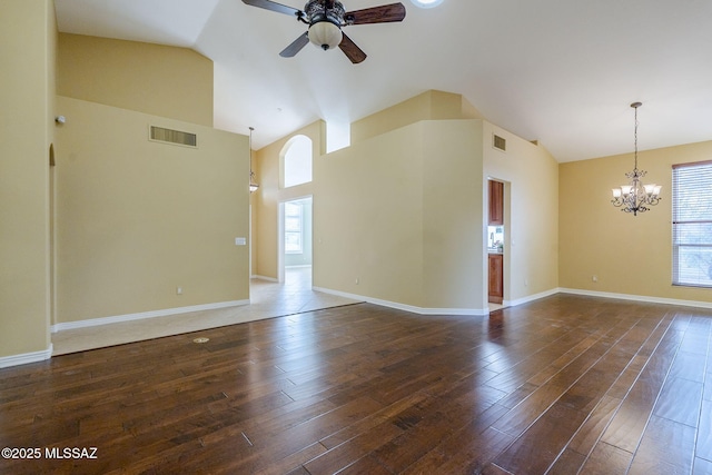 empty room featuring ceiling fan with notable chandelier, dark hardwood / wood-style floors, and high vaulted ceiling