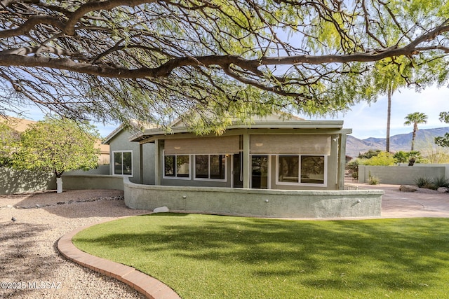 rear view of property featuring a lawn and a mountain view