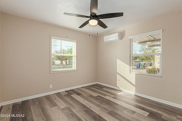 unfurnished room with hardwood / wood-style floors, ceiling fan, a wealth of natural light, and a wall mounted AC