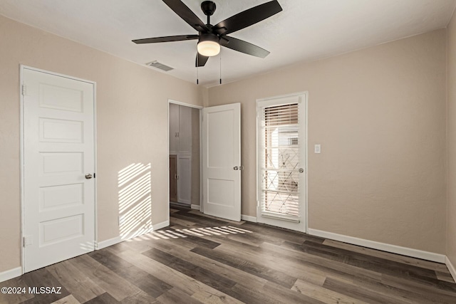 empty room with ceiling fan and dark hardwood / wood-style flooring