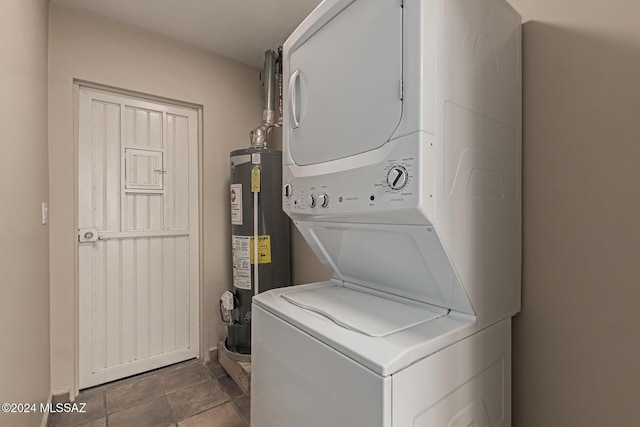 laundry room with tile patterned floors, gas water heater, and stacked washer / drying machine