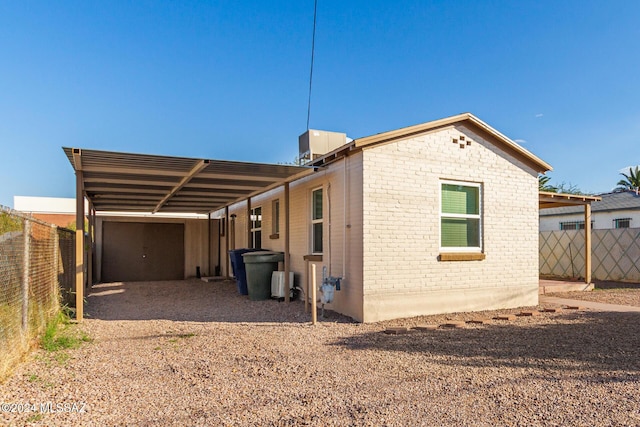 view of side of home with a carport and central air condition unit