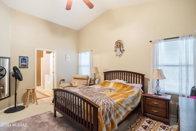 bedroom featuring ceiling fan, light carpet, high vaulted ceiling, and ensuite bath