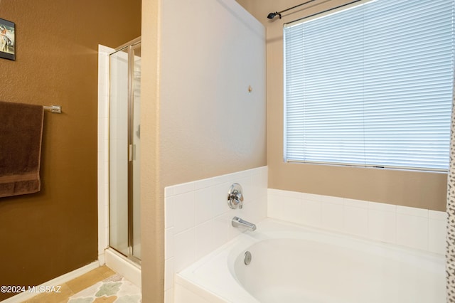 bathroom featuring separate shower and tub