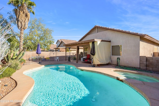 view of swimming pool with a patio area and an in ground hot tub