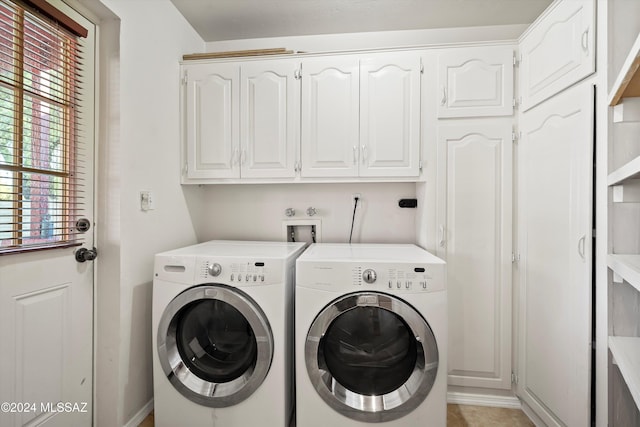 washroom featuring separate washer and dryer, light tile patterned flooring, and cabinets