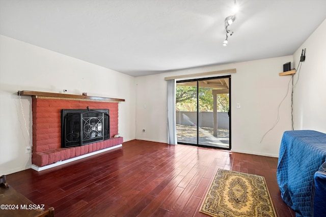 living room with hardwood / wood-style floors, a fireplace, and rail lighting