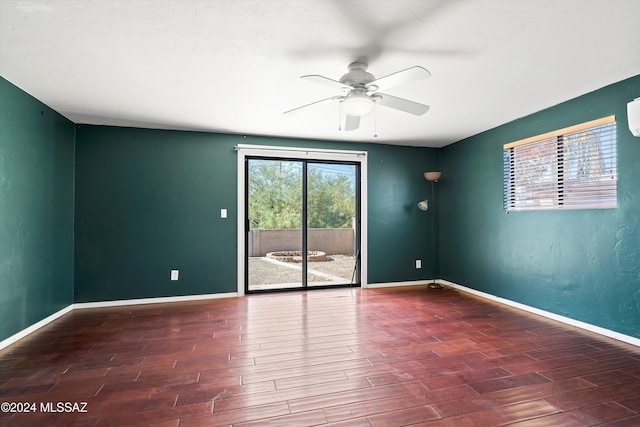 unfurnished room with ceiling fan and dark wood-type flooring