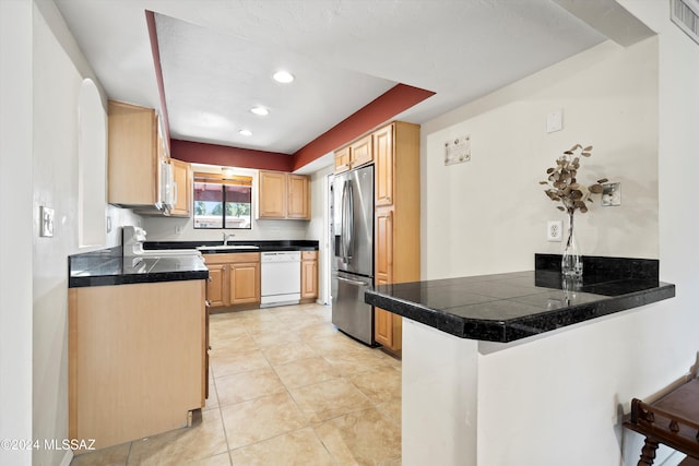 kitchen featuring dishwasher, sink, stainless steel refrigerator with ice dispenser, kitchen peninsula, and a kitchen bar