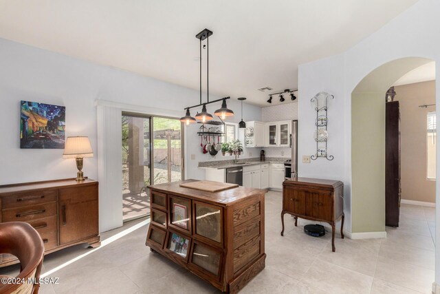 tiled home office featuring ceiling fan and a healthy amount of sunlight