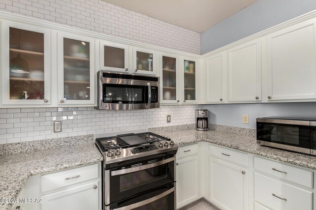 kitchen featuring hanging light fixtures, white cabinetry, appliances with stainless steel finishes, and sink