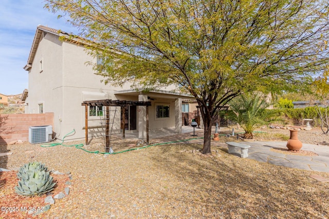 rear view of property featuring a pergola, central AC, and a patio area