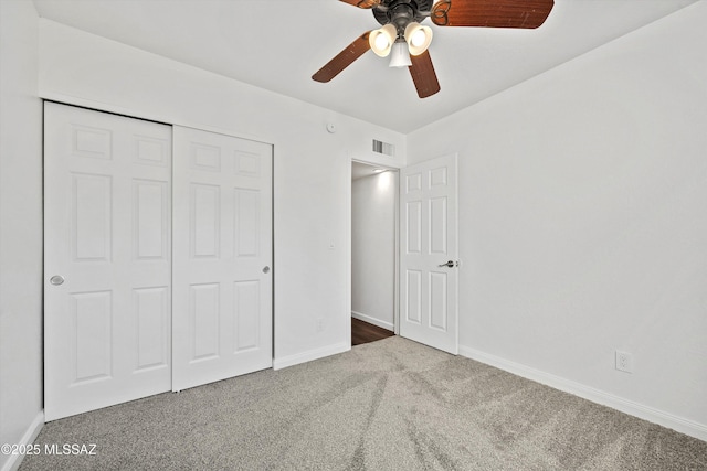 unfurnished bedroom with ceiling fan, a closet, and dark colored carpet