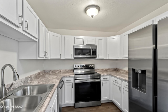 kitchen featuring white cabinetry, stainless steel appliances, dark hardwood / wood-style flooring, a textured ceiling, and sink