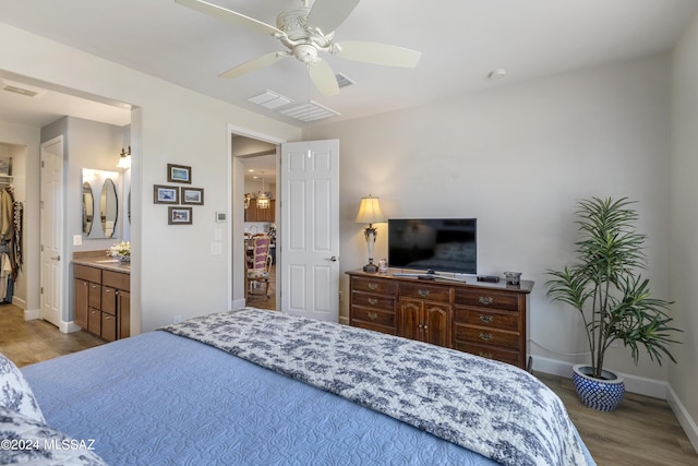 bedroom featuring ensuite bath, ceiling fan, and light hardwood / wood-style flooring