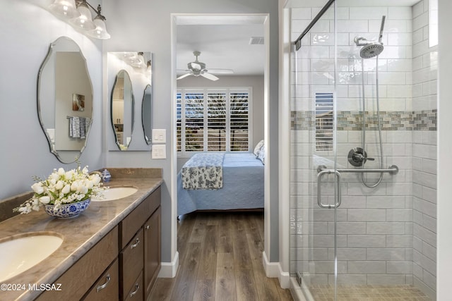 bathroom with wood-type flooring, vanity, ceiling fan, and walk in shower