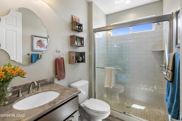 bathroom featuring walk in shower, vanity, and toilet