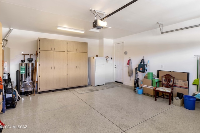 garage featuring white refrigerator, water heater, and a garage door opener