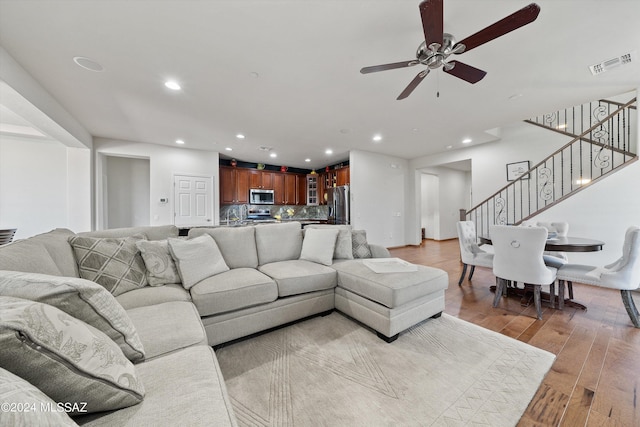 living area featuring light wood-style flooring, recessed lighting, a ceiling fan, visible vents, and stairway