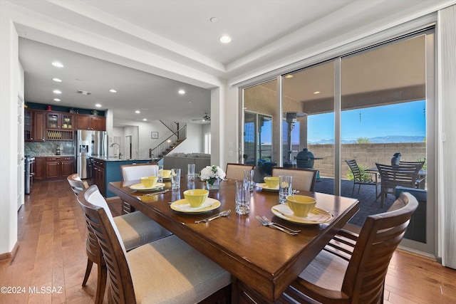 dining room featuring stairway, wood finished floors, and recessed lighting