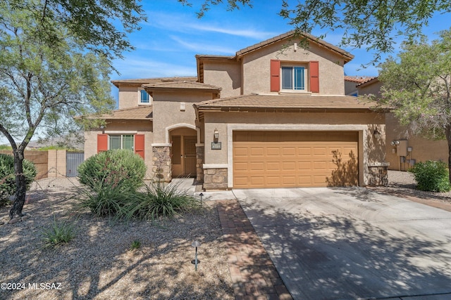 mediterranean / spanish-style house with stone siding, concrete driveway, a tile roof, and stucco siding