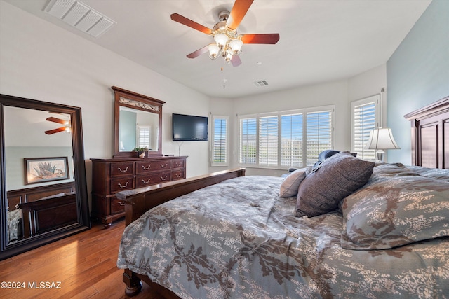 bedroom featuring ceiling fan, visible vents, and wood finished floors