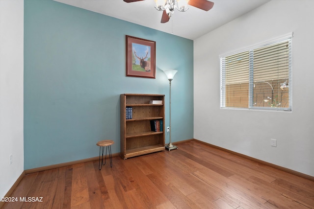 unfurnished room featuring light wood finished floors, a ceiling fan, and baseboards