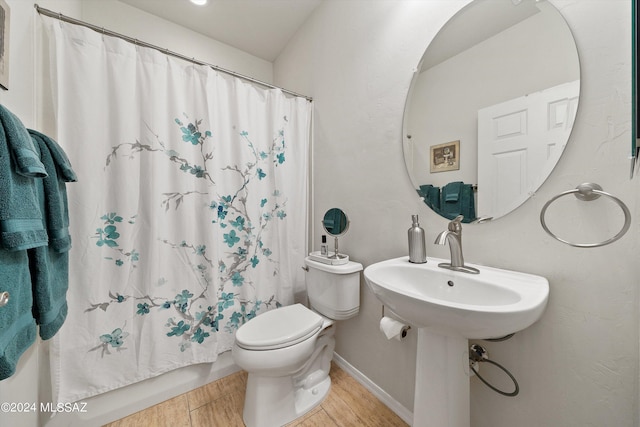 bathroom featuring a shower with shower curtain, baseboards, toilet, and wood finished floors