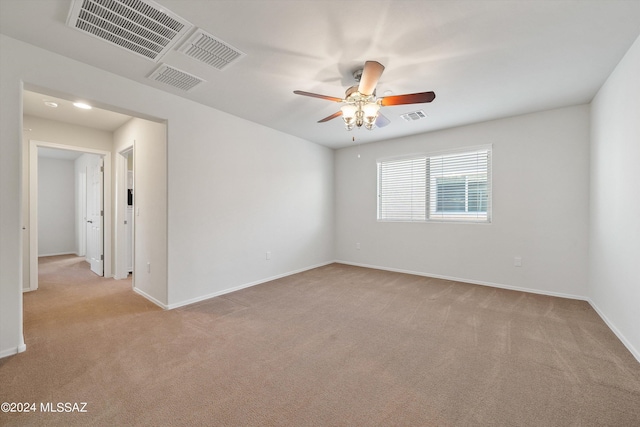 unfurnished room featuring baseboards, visible vents, ceiling fan, and light colored carpet