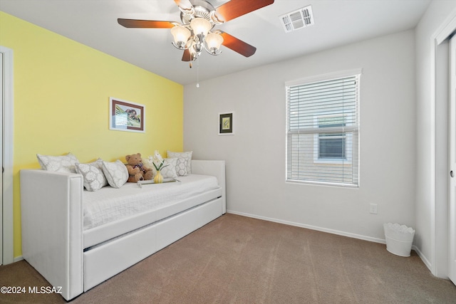 bedroom with baseboards, a ceiling fan, visible vents, and light colored carpet