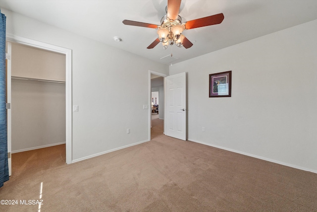 unfurnished bedroom with carpet floors, a spacious closet, and a closet