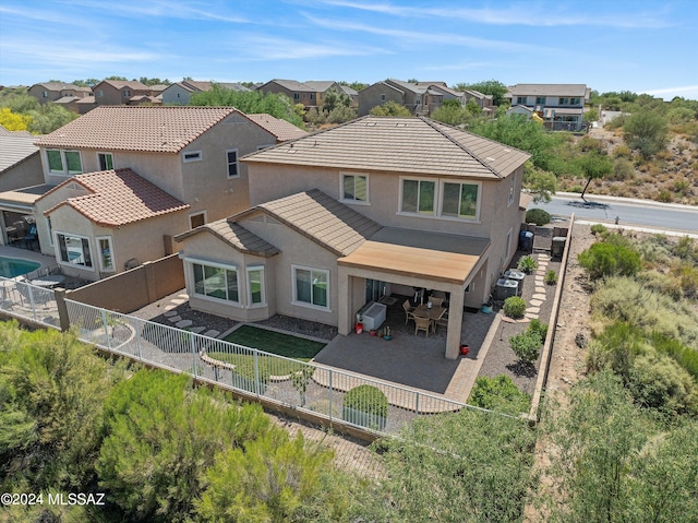 rear view of house with a fenced backyard, a residential view, and stucco siding