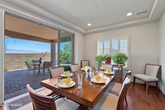 dining space with a healthy amount of sunlight, visible vents, and a raised ceiling