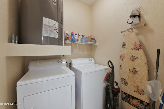 washroom with washing machine and clothes dryer and water heater