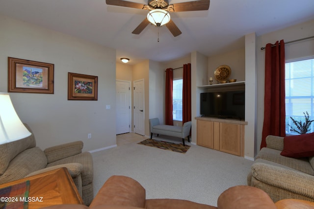 carpeted living room with ceiling fan