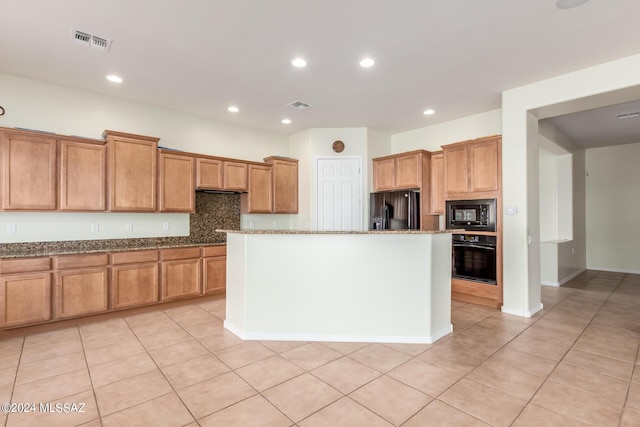 kitchen featuring light tile patterned flooring, tasteful backsplash, light stone counters, a center island, and black appliances