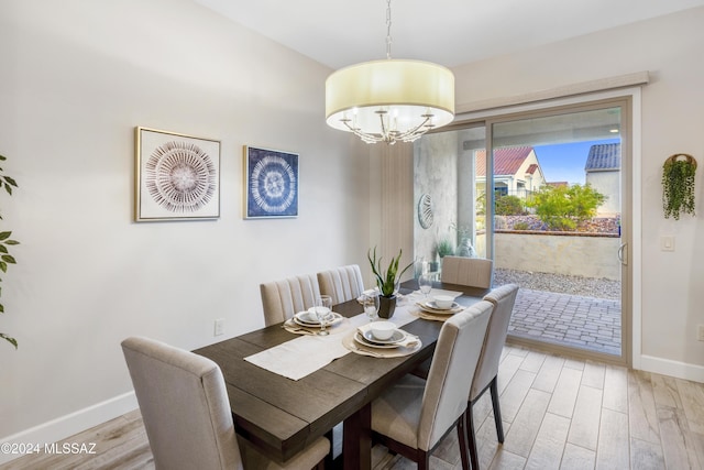 dining space featuring a notable chandelier and light wood-type flooring