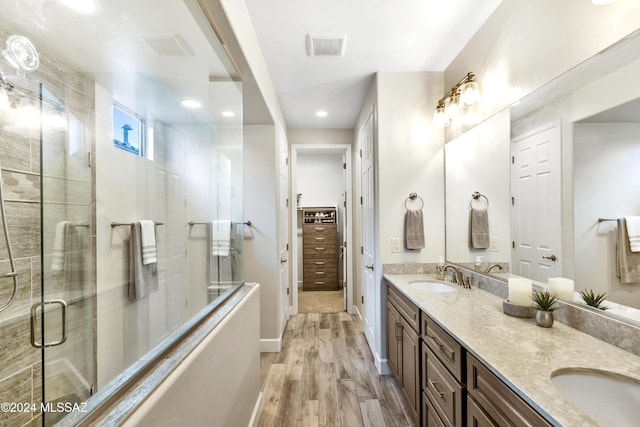 bathroom featuring hardwood / wood-style floors, vanity, and a shower with shower door