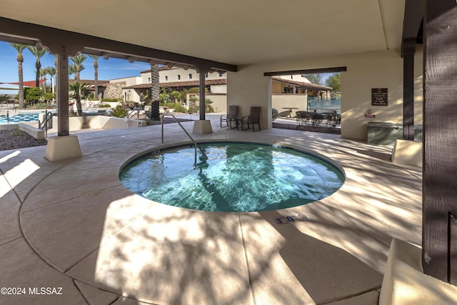 view of pool featuring a community hot tub and a patio area