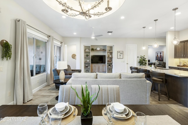 living room with sink, light hardwood / wood-style floors, and a notable chandelier