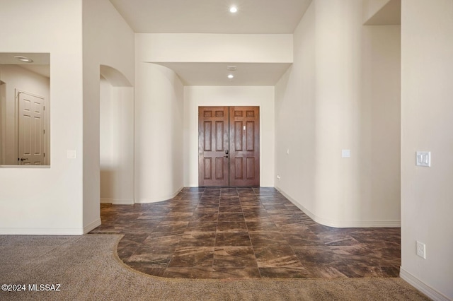 entrance foyer with dark colored carpet